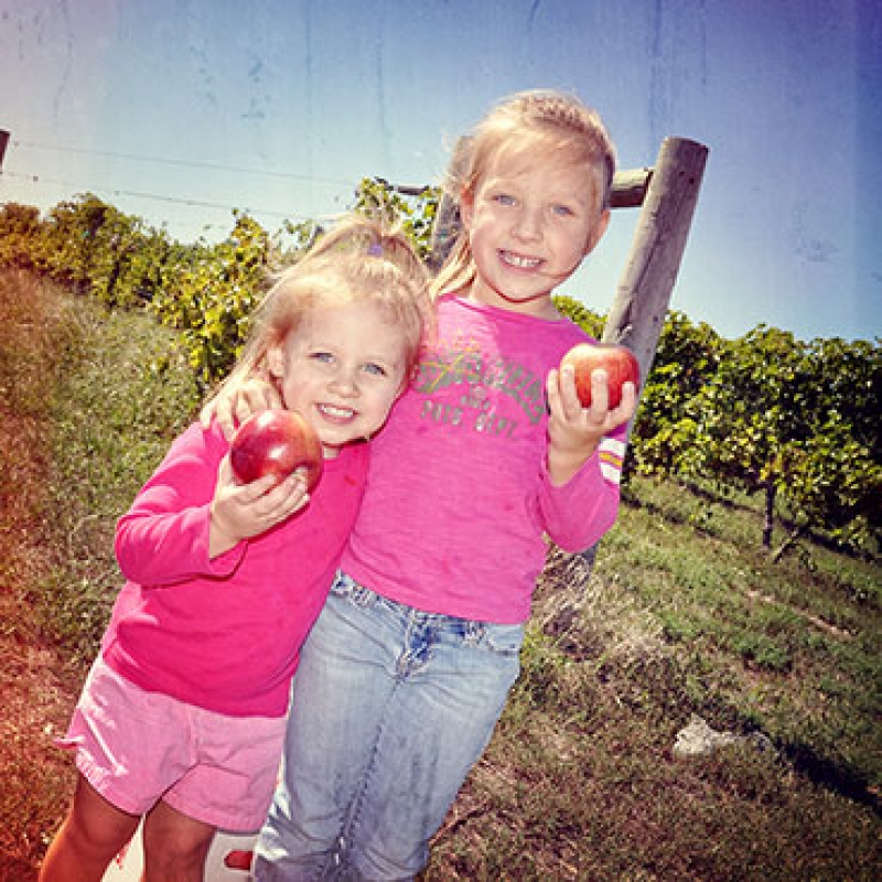 two girls holding apples