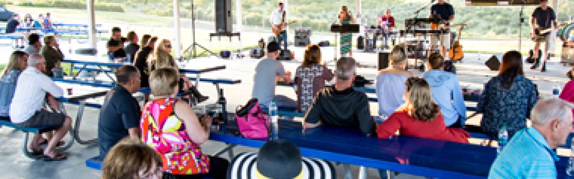 people sitting on benches at music event