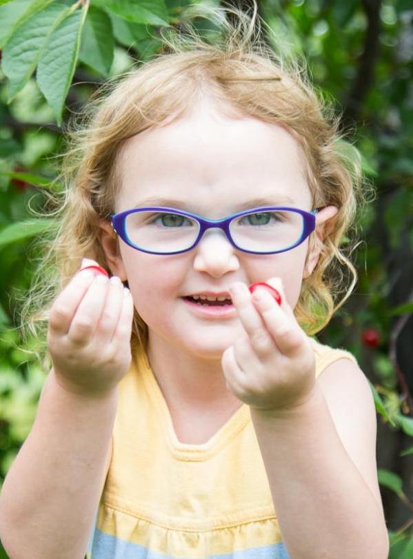 girl holding cherries