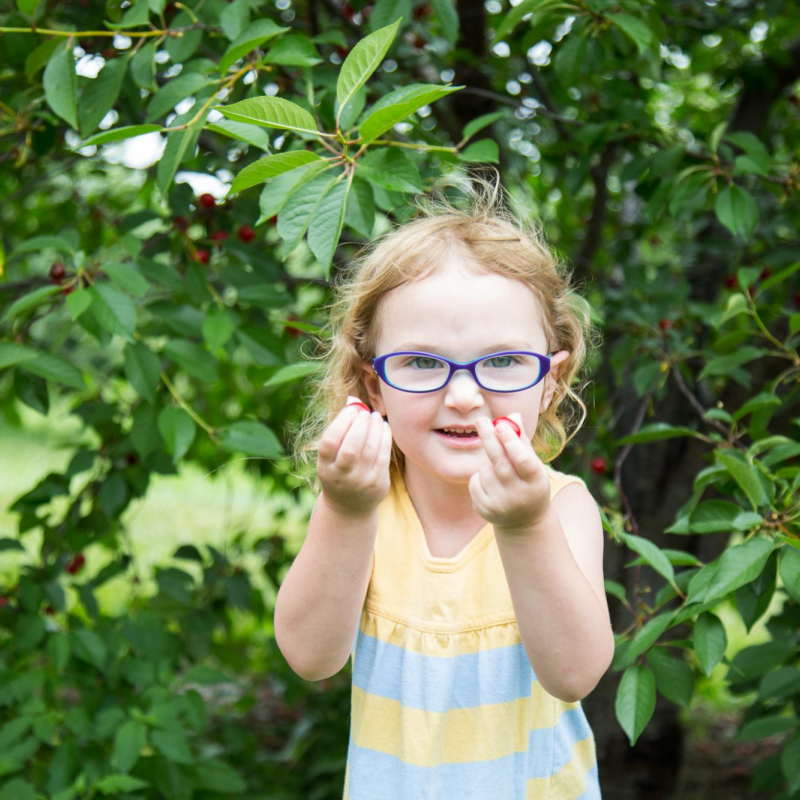 girl holding cherries